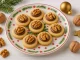 Walnußplätzchen mit Nougat und halber Walnuss als Dekoration auf weihnachtlichem Teller serviert