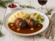 Winzerroulade aus Rindfleisch in Weinblättern und Speck, serviert mit Rotweinsauce, Kartoffelpüree und Selleriesalat
