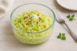 Roher Lauchsalat mit Äpfeln, Sellerie und Joghurt in moderner Glasschüssel serviert