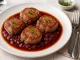 Kalbsmedaillons mit Rotwein-Schalotten-Sauce auf Teller angerichtet, garniert mit Thymian