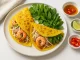 Knusprige vietnamesische Reispfannkuchen Bánh Xèo modern angerichtet auf weißem Teller mit Garnelen, Kräutern und Dip