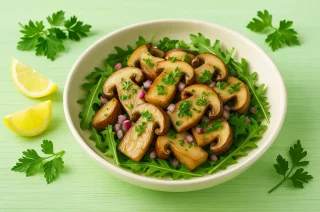 Steinpilzsalat mit frischen Kräutern und Zwiebeln auf hellgrünem Holztisch mit deutlicher Maserung, serviert in heller Schüssel
